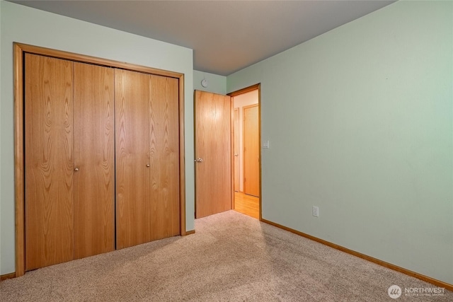 unfurnished bedroom featuring a closet, baseboards, and carpet floors