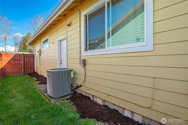 view of home's exterior with cooling unit and fence