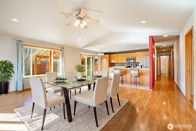 dining room with a ceiling fan, vaulted ceiling, recessed lighting, and light wood-style floors