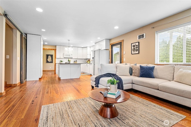 living room featuring recessed lighting, visible vents, and light wood-style flooring