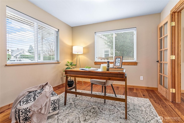 office area with baseboards and wood finished floors