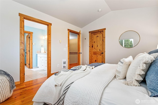 bedroom featuring lofted ceiling and light wood-style flooring