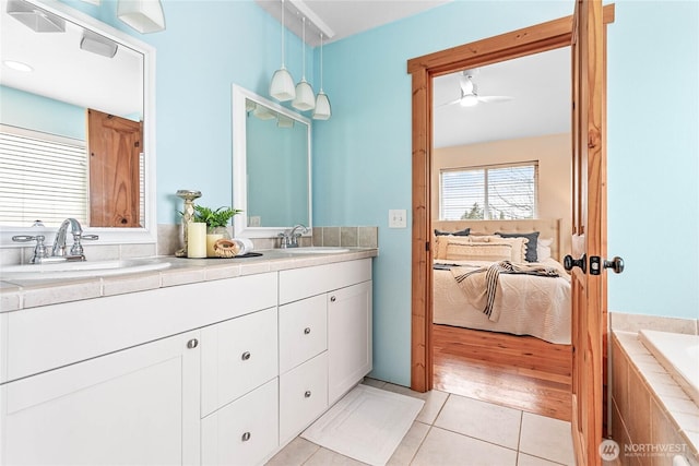 bathroom with tile patterned floors, double vanity, ensuite bath, and a sink