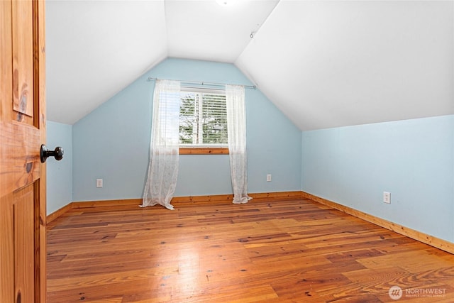 bonus room featuring lofted ceiling, baseboards, and wood-type flooring