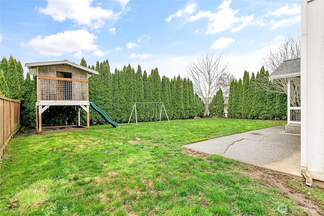 view of yard with a patio, a playground, and a fenced backyard