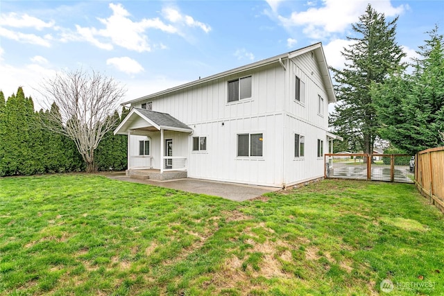 back of property featuring a yard, a patio, board and batten siding, and fence