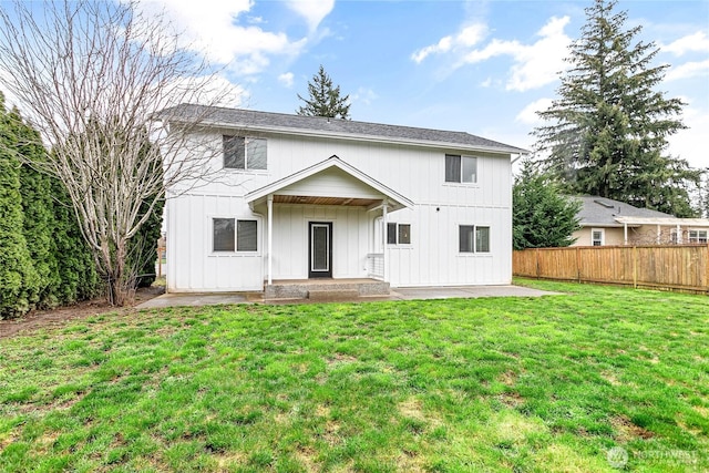 view of front facade featuring a front lawn, fence, board and batten siding, and a patio area