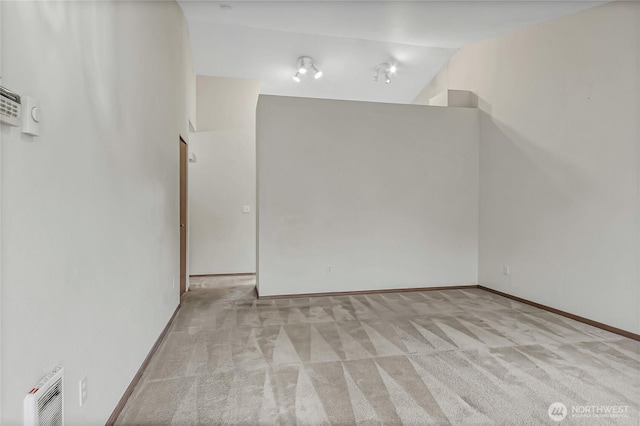 unfurnished room featuring carpet floors, baseboards, and lofted ceiling