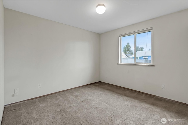 carpeted spare room with baseboards