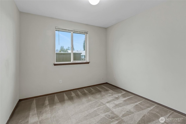 carpeted spare room with baseboards