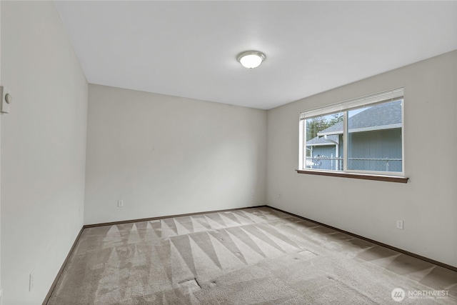 carpeted spare room with baseboards