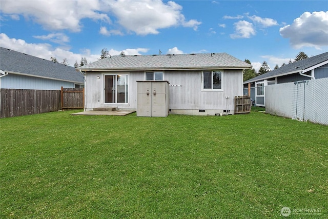 rear view of house with a yard, a shingled roof, crawl space, and a fenced backyard