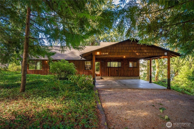 rustic home featuring driveway and an attached carport