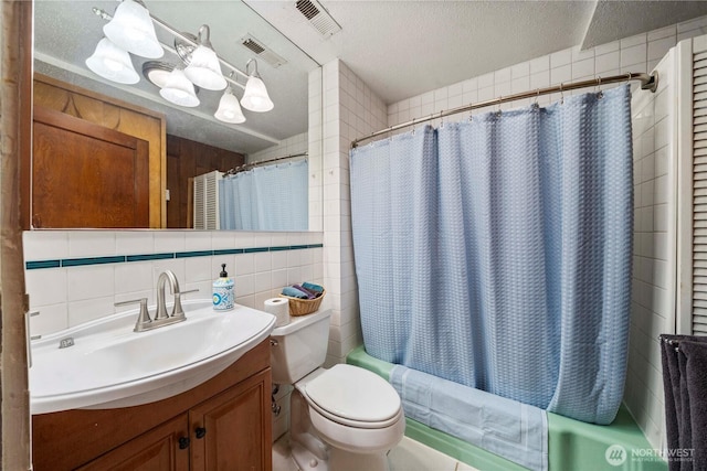 full bath with toilet, vanity, shower / bath combination with curtain, a textured ceiling, and tile walls