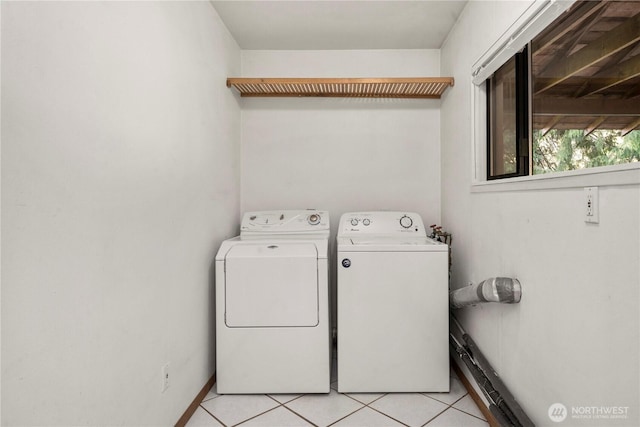 laundry area featuring laundry area, washing machine and clothes dryer, and light tile patterned floors