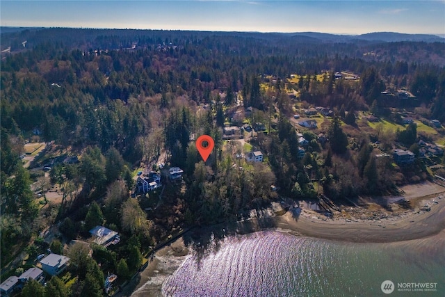 birds eye view of property with a wooded view and a water and mountain view