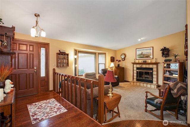 living room with lofted ceiling, wood finished floors, and a tile fireplace