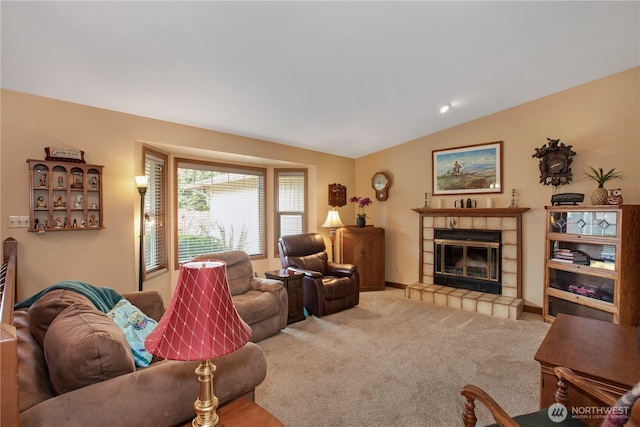 living area with carpet floors, a tile fireplace, baseboards, and lofted ceiling