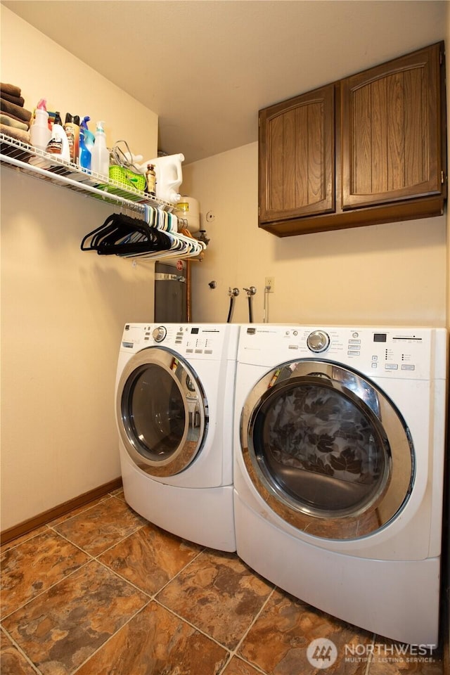 washroom featuring washer and dryer, cabinet space, and baseboards