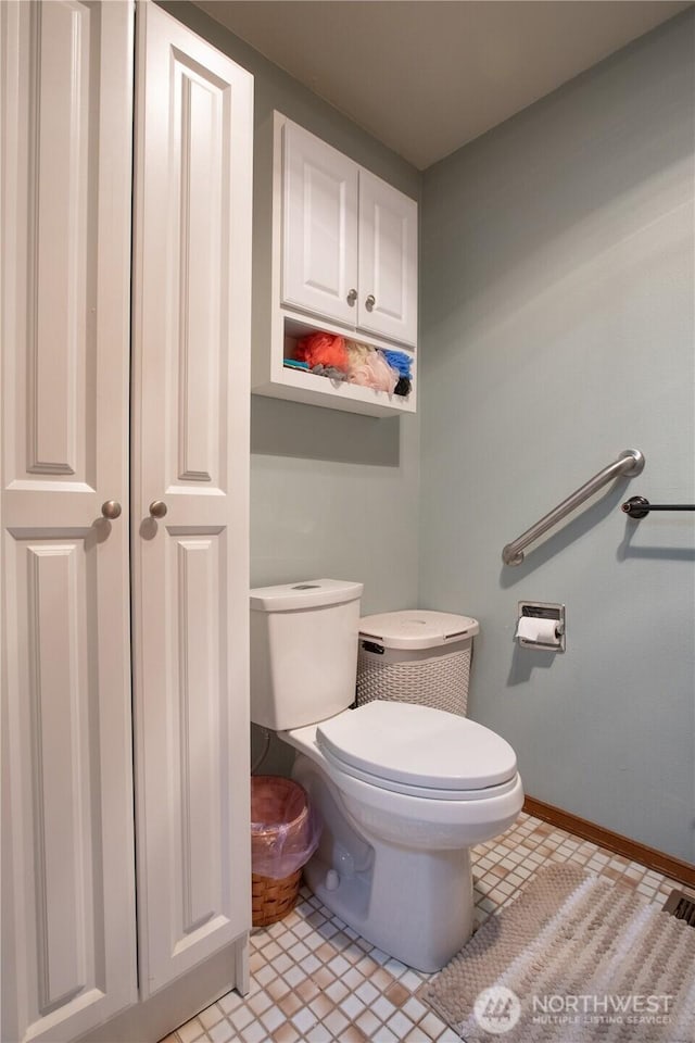 bathroom with baseboards and toilet