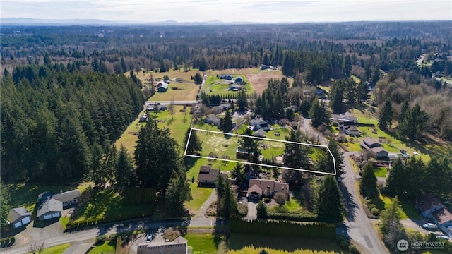 drone / aerial view with a wooded view