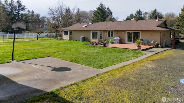 rear view of house with a yard and fence