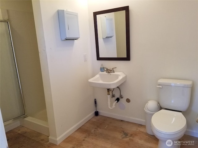 bathroom featuring baseboards, toilet, and a shower stall