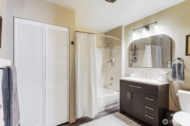 bathroom with a closet, vanity, toilet, and shower / tub combo with curtain