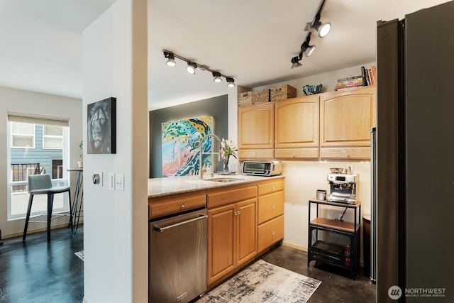 kitchen featuring concrete floors, baseboards, light brown cabinetry, appliances with stainless steel finishes, and a sink