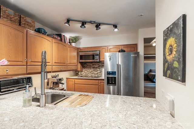 kitchen with stainless steel appliances, brown cabinets, backsplash, and a toaster