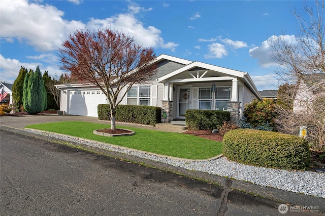 view of front of property featuring driveway, stone siding, an attached garage, and a front yard