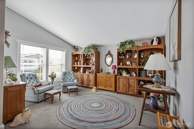 sitting room featuring light carpet and vaulted ceiling