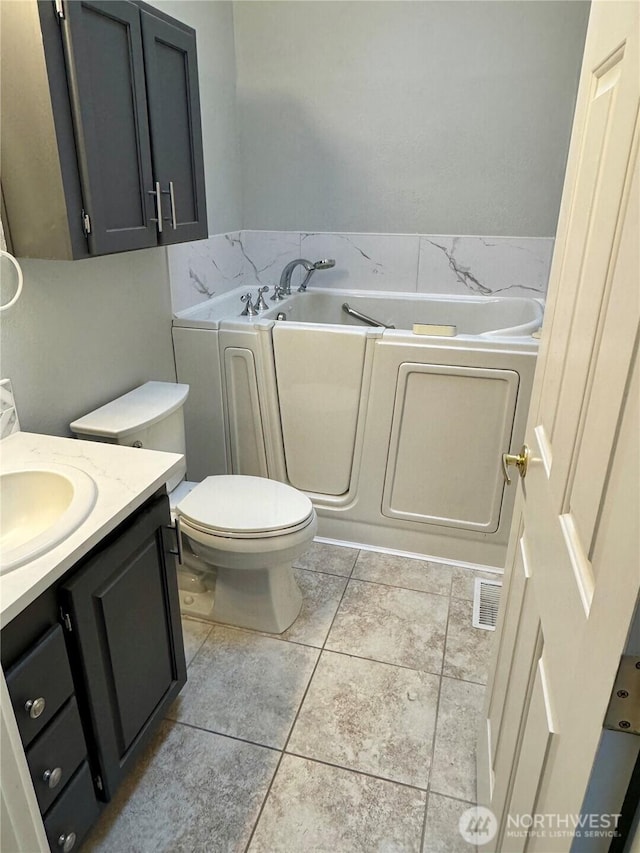 full bathroom featuring visible vents, toilet, tile patterned floors, vanity, and a bath