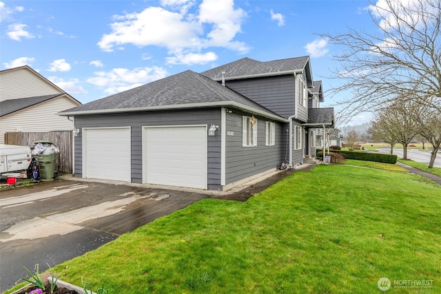 view of home's exterior with a garage, fence, driveway, roof with shingles, and a lawn