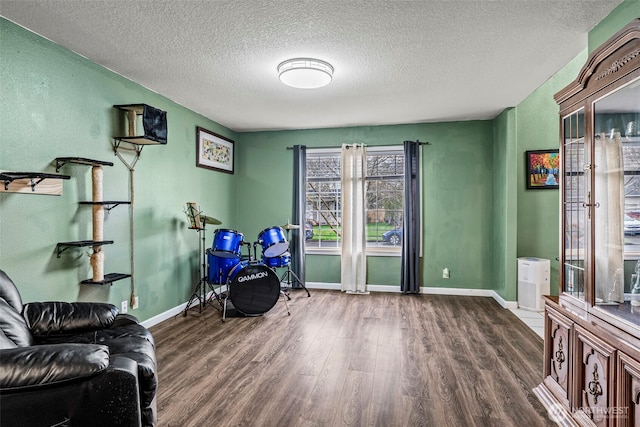 interior space featuring a textured ceiling, baseboards, and wood finished floors