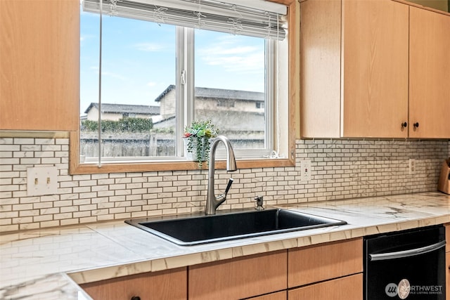 kitchen featuring tasteful backsplash, light countertops, a sink, and dishwasher