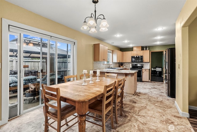 dining room with baseboards, plenty of natural light, and an inviting chandelier