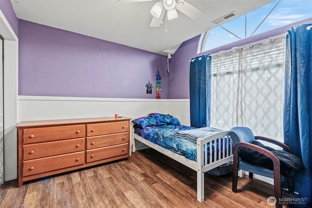 bedroom featuring lofted ceiling, visible vents, ceiling fan, and wood finished floors