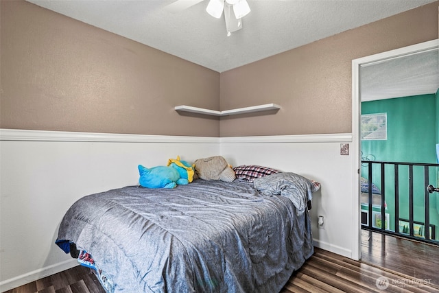 bedroom with ceiling fan, baseboards, and wood finished floors