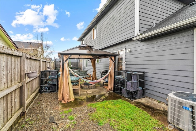 view of yard with central AC, a fenced backyard, and a gazebo