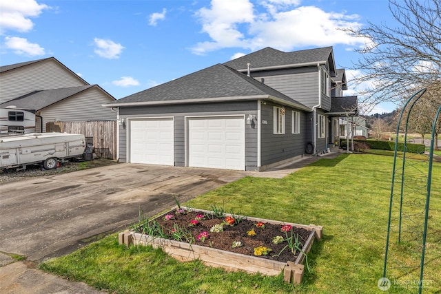 view of home's exterior with fence, a yard, roof with shingles, an attached garage, and a garden