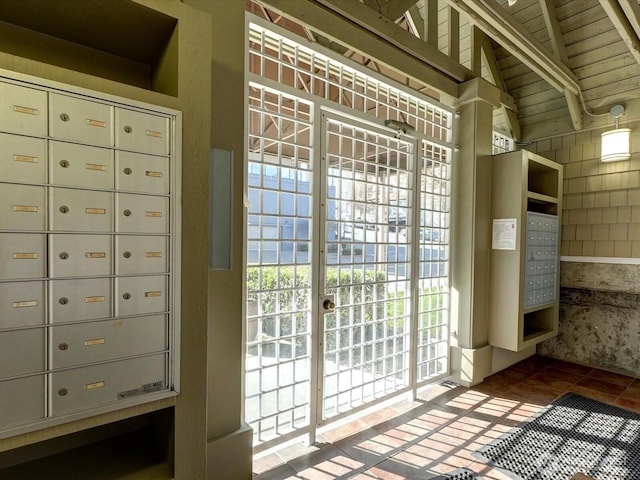 doorway featuring lofted ceiling with beams, wooden ceiling, and mail area