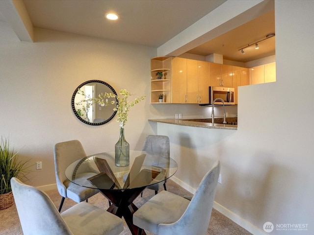 carpeted dining space featuring rail lighting, baseboards, and recessed lighting