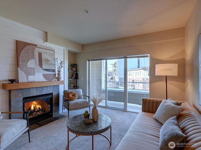 carpeted living area with a tiled fireplace