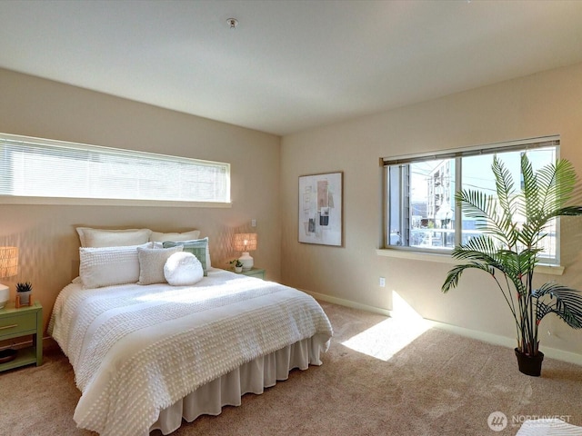 bedroom featuring multiple windows, baseboards, and light colored carpet