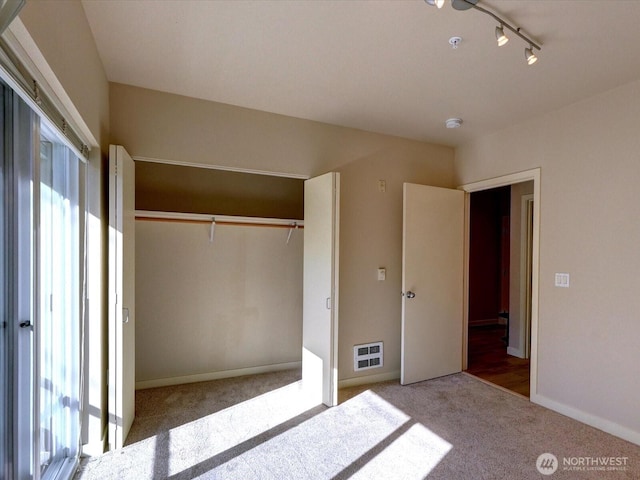 unfurnished bedroom with carpet, a closet, visible vents, and baseboards