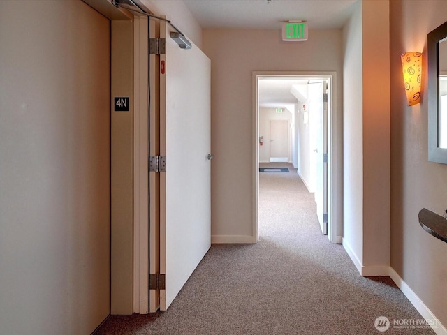 hall featuring carpet flooring and baseboards