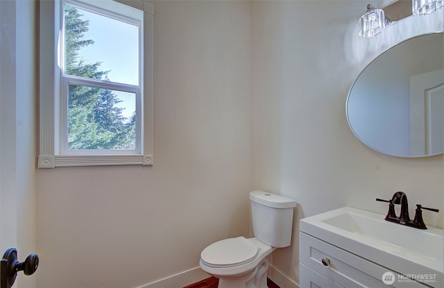 bathroom with toilet, baseboards, and vanity