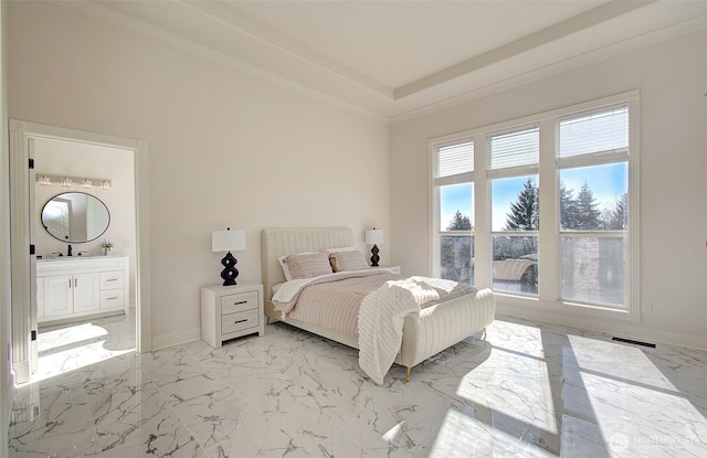 bedroom with marble finish floor, ensuite bath, a raised ceiling, and baseboards