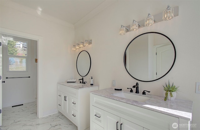 bathroom featuring marble finish floor, two vanities, a sink, and baseboards